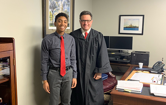 student with judge smiling at camera for job shadowing