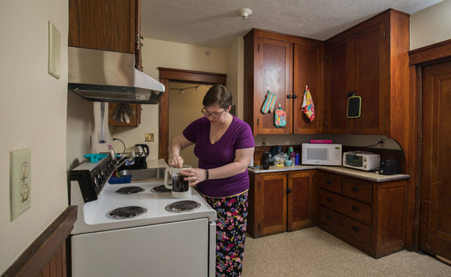 graduate housing: 926 Main St. Apartment Kitchen with female cooking at stove