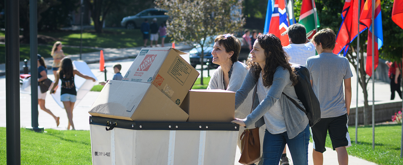 Student and mother pushing load of boxes for move-in day