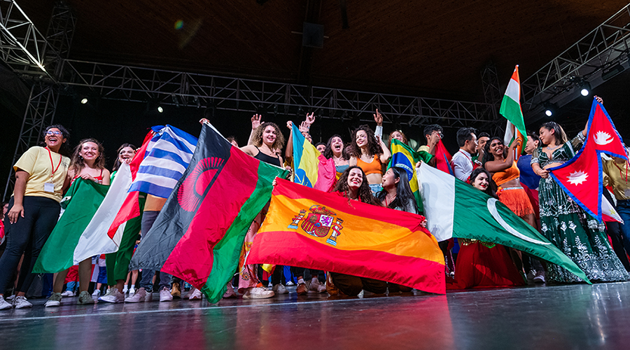 international students waving flags on stage