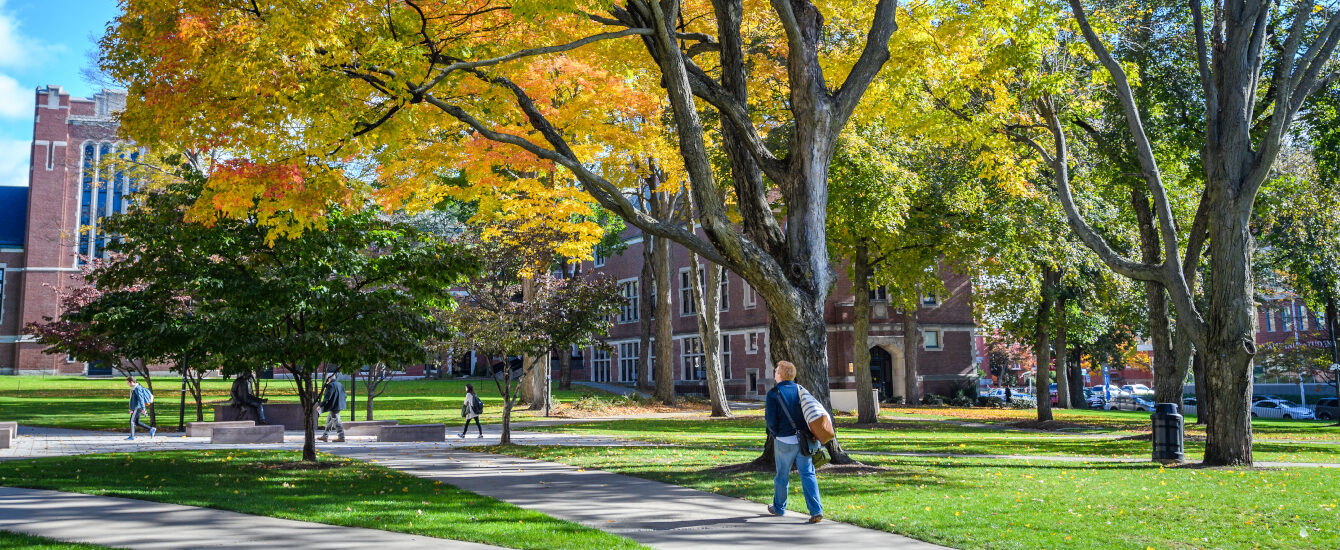 Student walking on Clark University campus in the fall