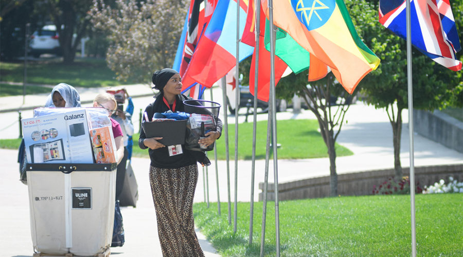 Student on campus with international flags on lawn