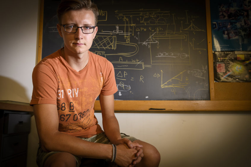 Nikolay Ionkin sitting in front of chalk board
