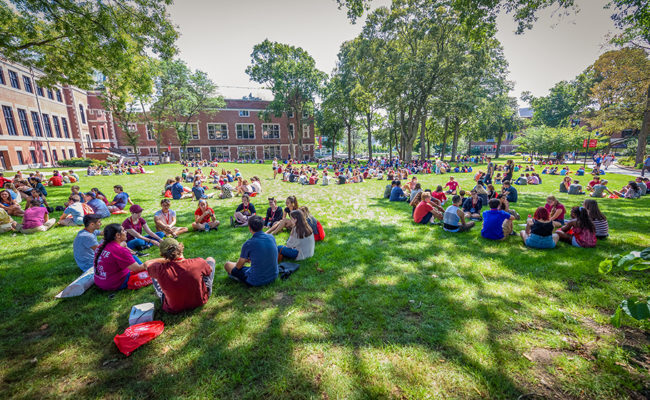 Students sitting on lawn in large group