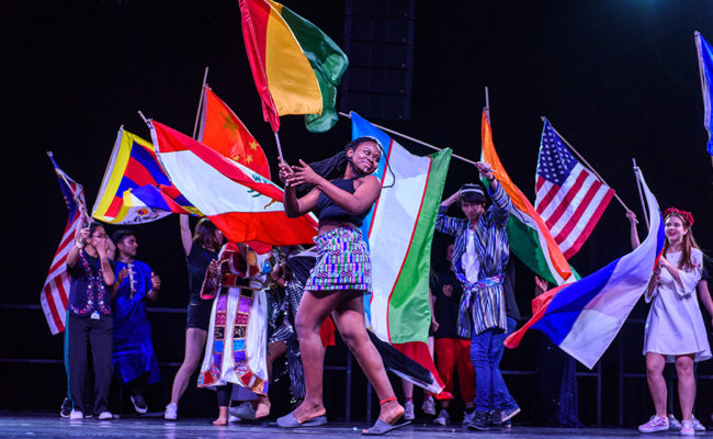 performers on stage with flags