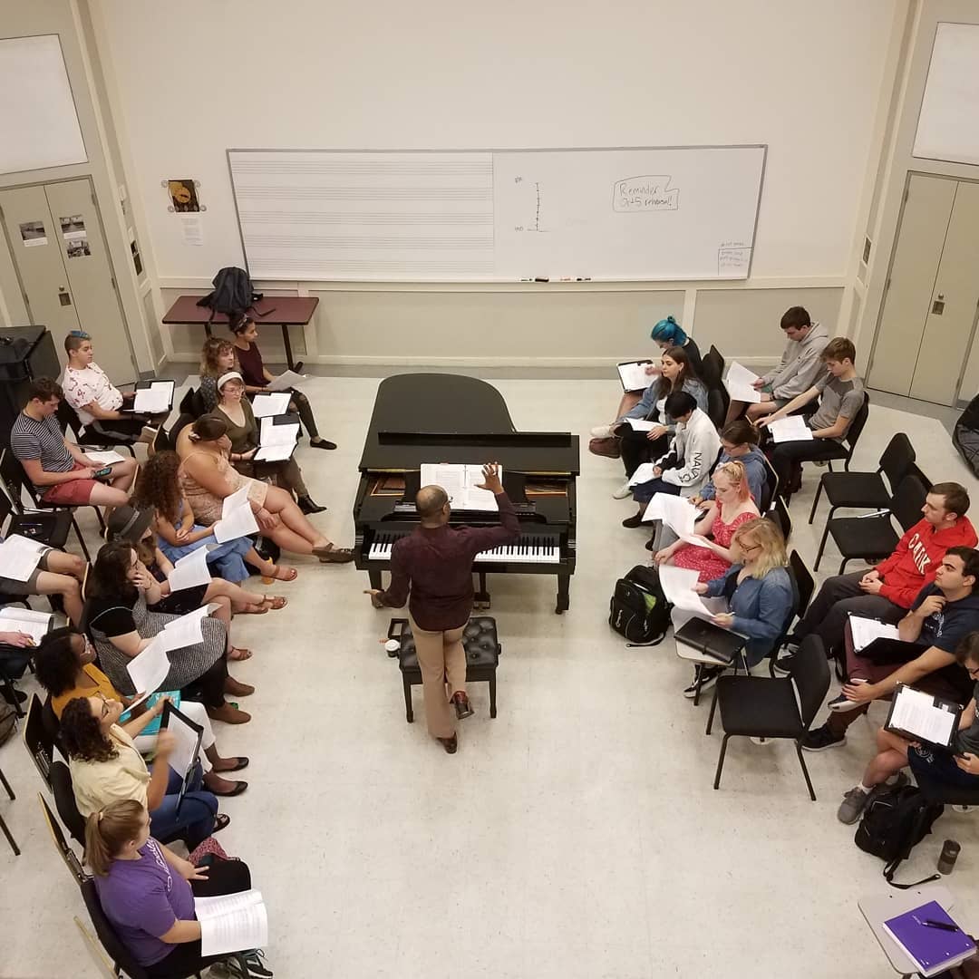Professor Cailin Manson instructs students in front of a piano