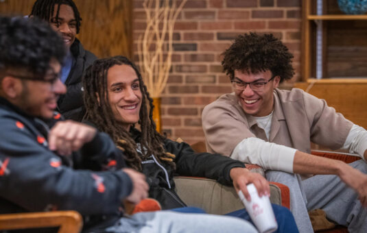 A group of students share a laugh during a gathering of the Men of Color Alliance at Clark University