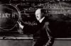 Robert Goddard posing with writings on a blackboard