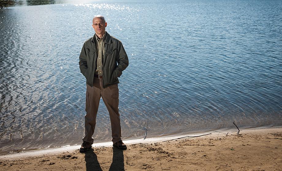 Robert Johnston, professor of economics, standing on beach in front of lake