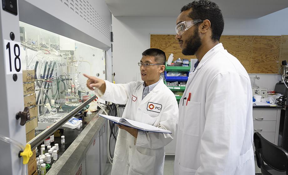 Above, Michael Kebede, right, works with Dr. Jia Wei, Ph.D. ’15, a research scientist at PCI Synthesis.
