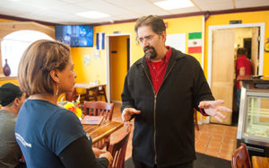 Professor Ramón Borges-Méndez chats with an employee at the Hacienda Don Juan Restaurant on Main Street. (Photo by Steve King)