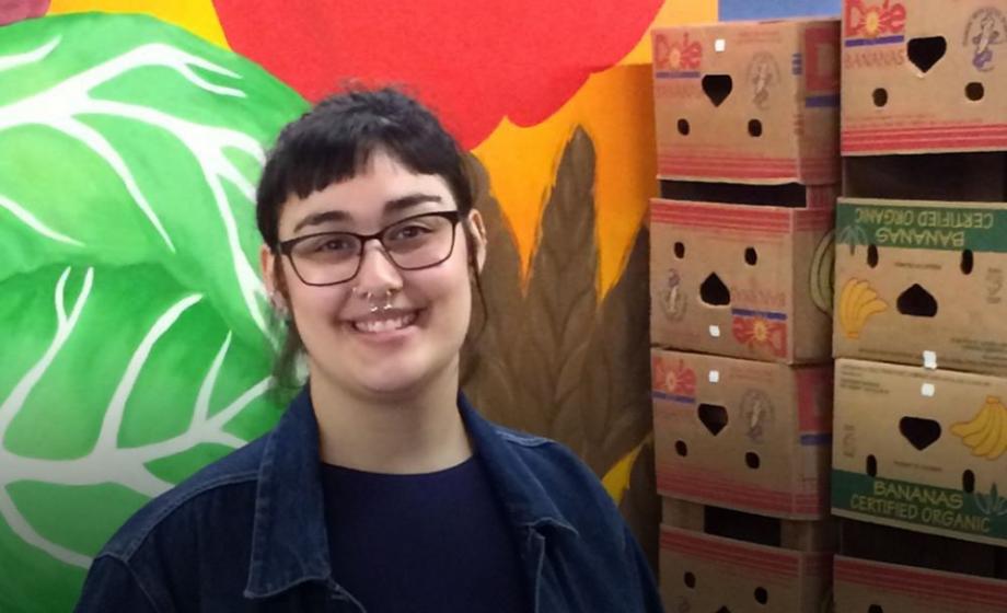 Clark University Katlyn Greger stands by a portion of her mural at the Worcester County Food Bank in Shrewsbury