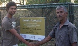 Sanjiv Fernando '15 (left) shakes hands with W.P. Piyadasa, a cattle herder who received one of Fernando's leopard-proof mesh enclosures.