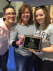 From left to right: Nichole Lopez '12, Maureen Hession from Clark's Philosophy Department, and Cassandra's roommate Lisa Taylor '11 hold up a plaque that the American Cancer Society created honoring McCann.