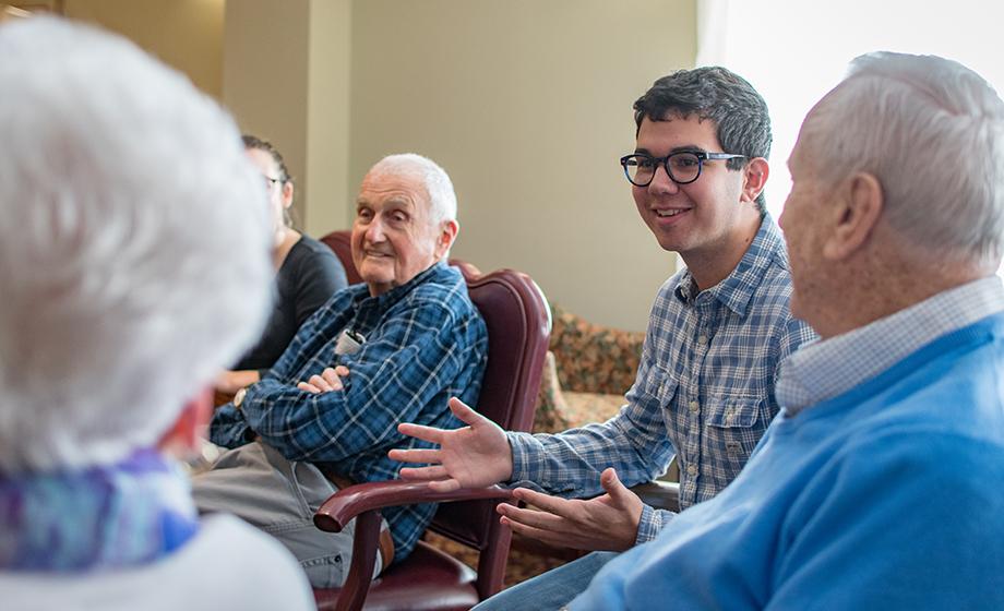 Jeremy Maltz ’20, right, listens to retirees describe their technology experience; at left is alumnus Kenneth Hedenburg '50, who has a degree in business administration from Clark.