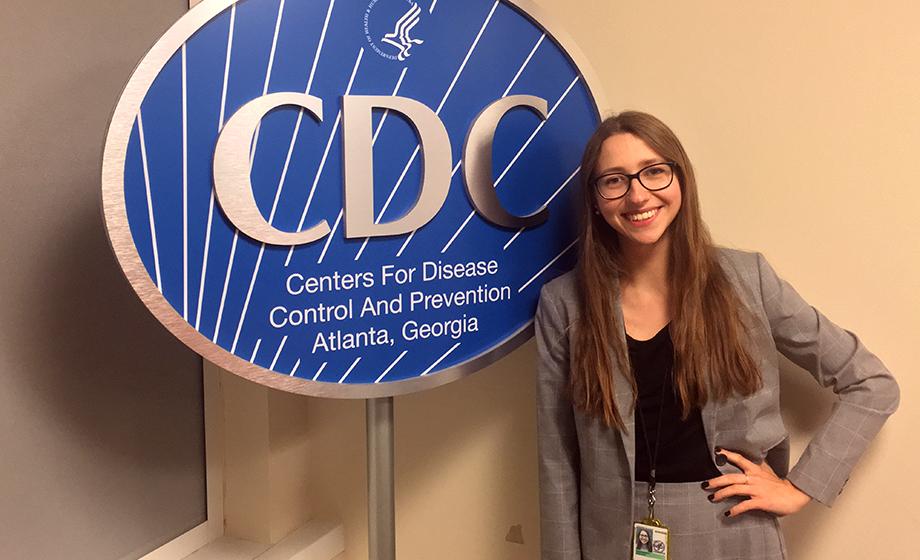 female student sitting in front of CDC sign