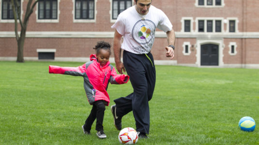 mohamed playing soccer with a child