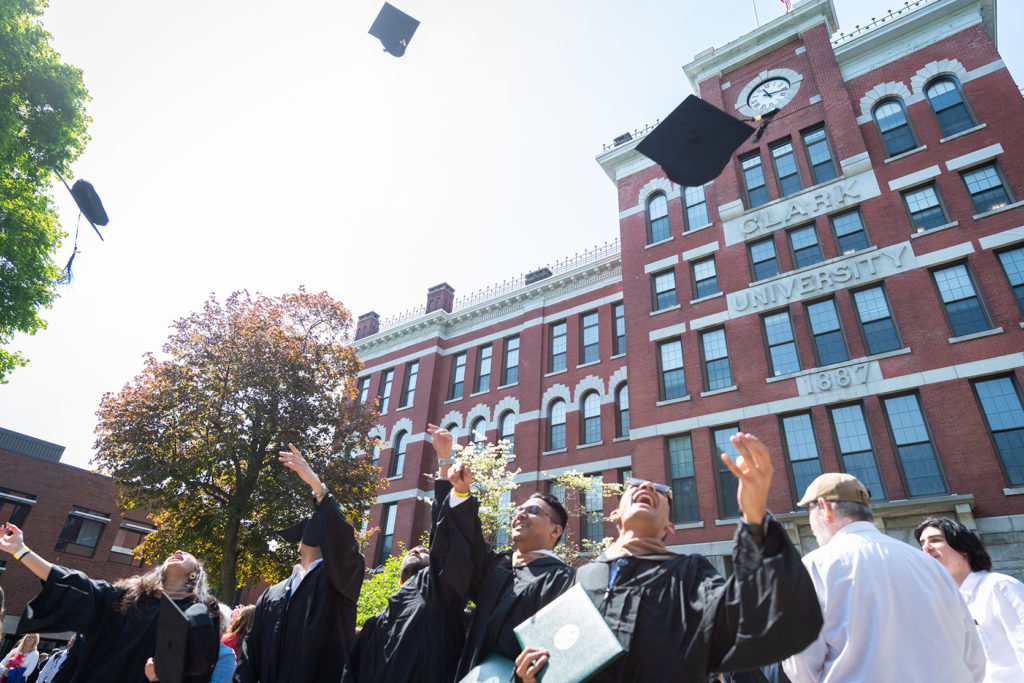Members of the Clark University Class of 2019 toss their caps after graduation
