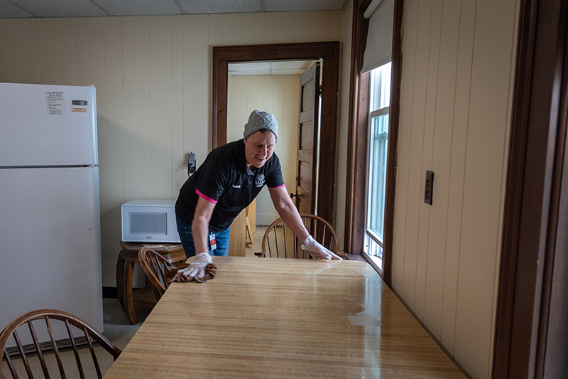 Facilities worker sanitizes student housing