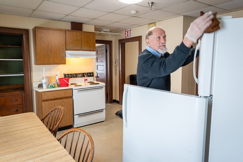 Bill Racki of Clark University Facilities Management cleans a student apartment