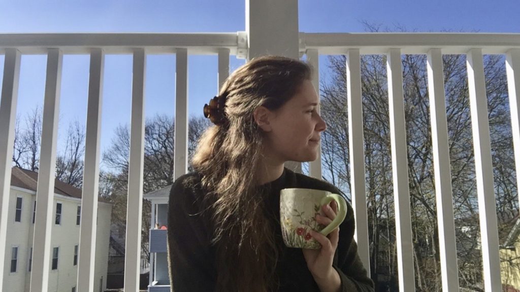 Erin Shull '19, MBA '20, sits on her porch in Worcester