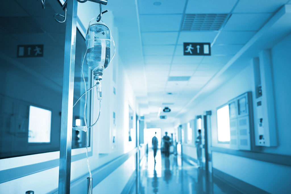 Doctors in emergency room hallway with IV drip