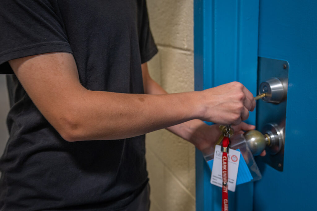Student opening residence hall door with key