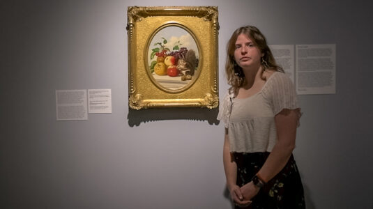Maire O'Donnell with “Still Life with Squirrel” by artist John J. Eyres. The painting is at the center of “Nuts and Berries,” the exhibition she curated for the Fitchburg Art Museum, which will be on display until Jan. 22, 2022.