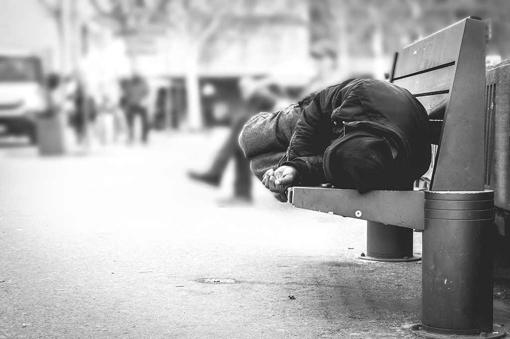 homeless man sleeping on bench
