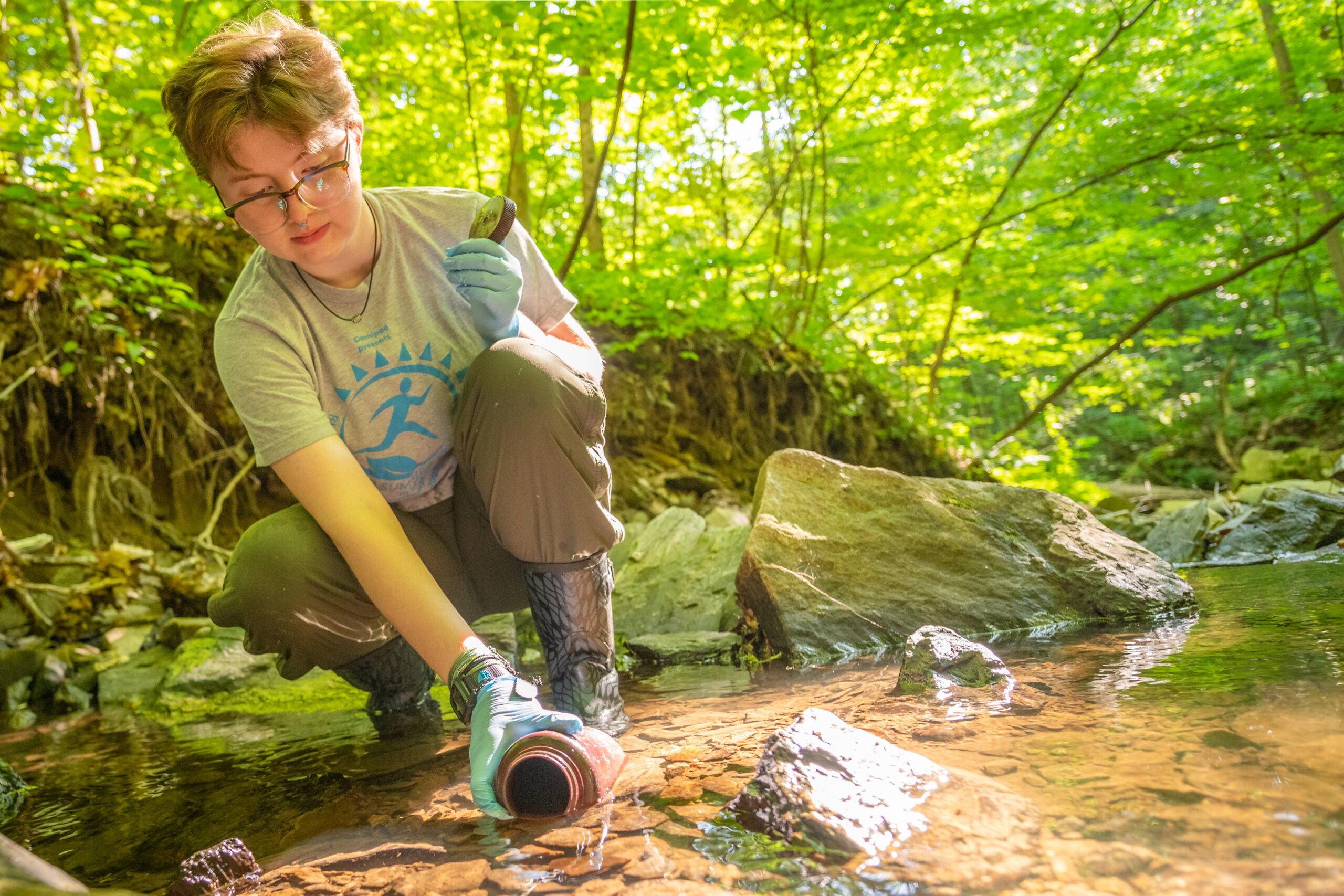 student collects water sample