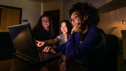 three students at laptop