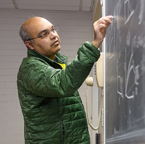 Arshad Kudrolli writing on chalkboard