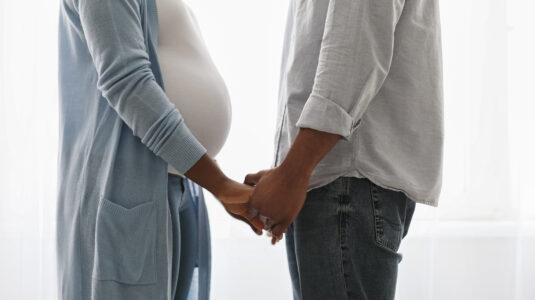 pregnant couple holding hands