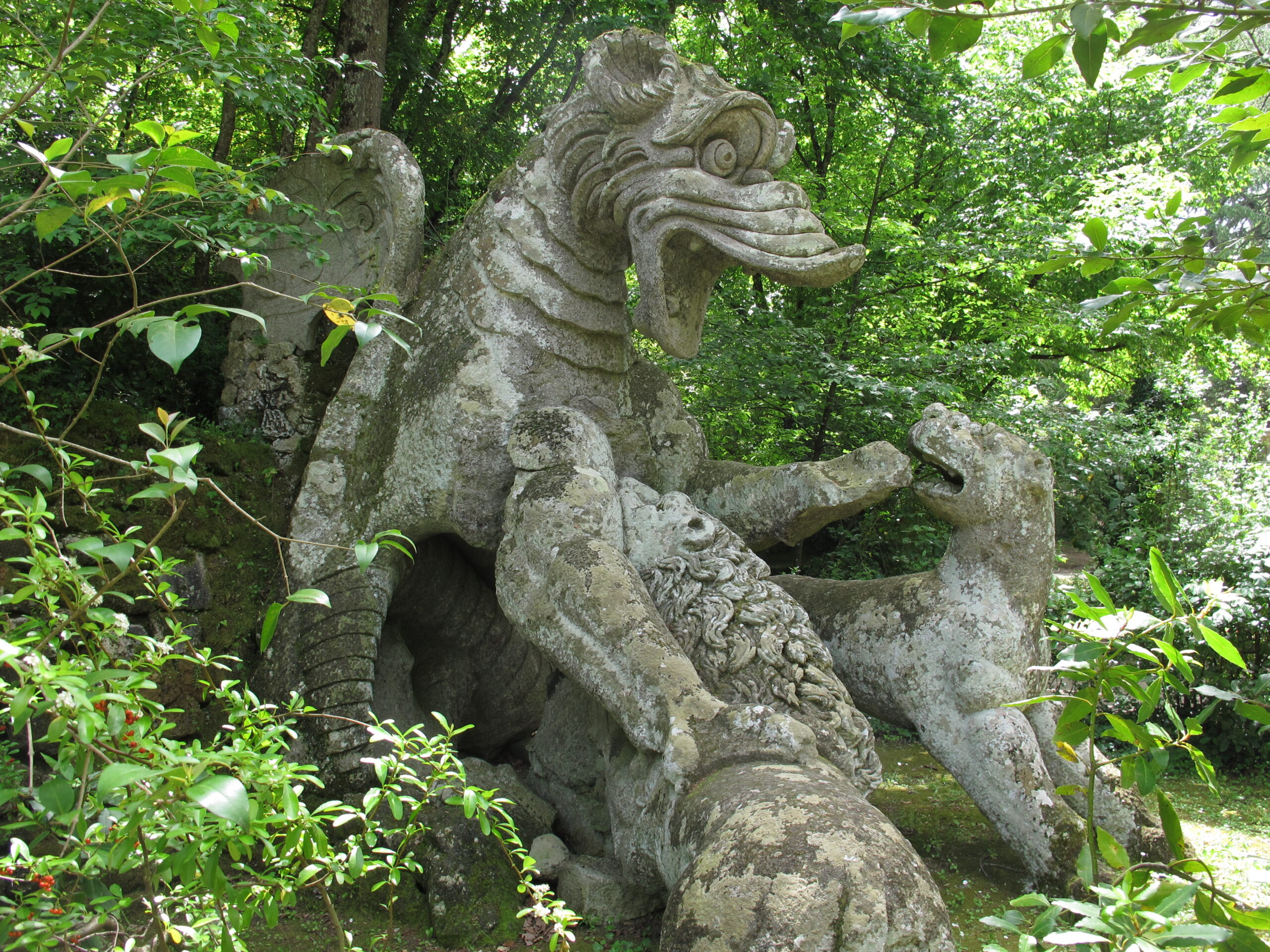 A sculpture of a dragon fighting with lions in Bomarzo, Italy