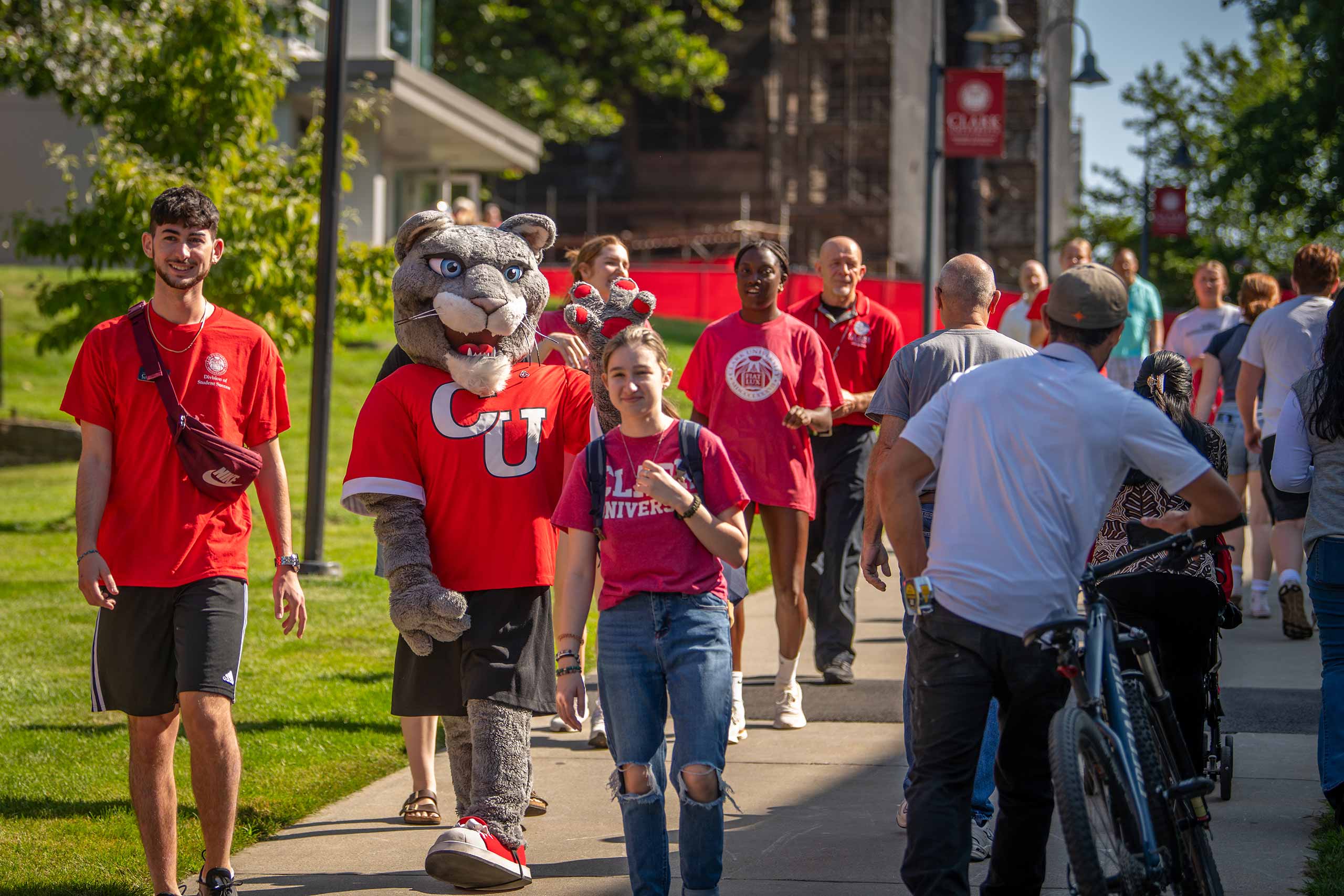 Thecougar walking on a crowded sidewalk with students and families