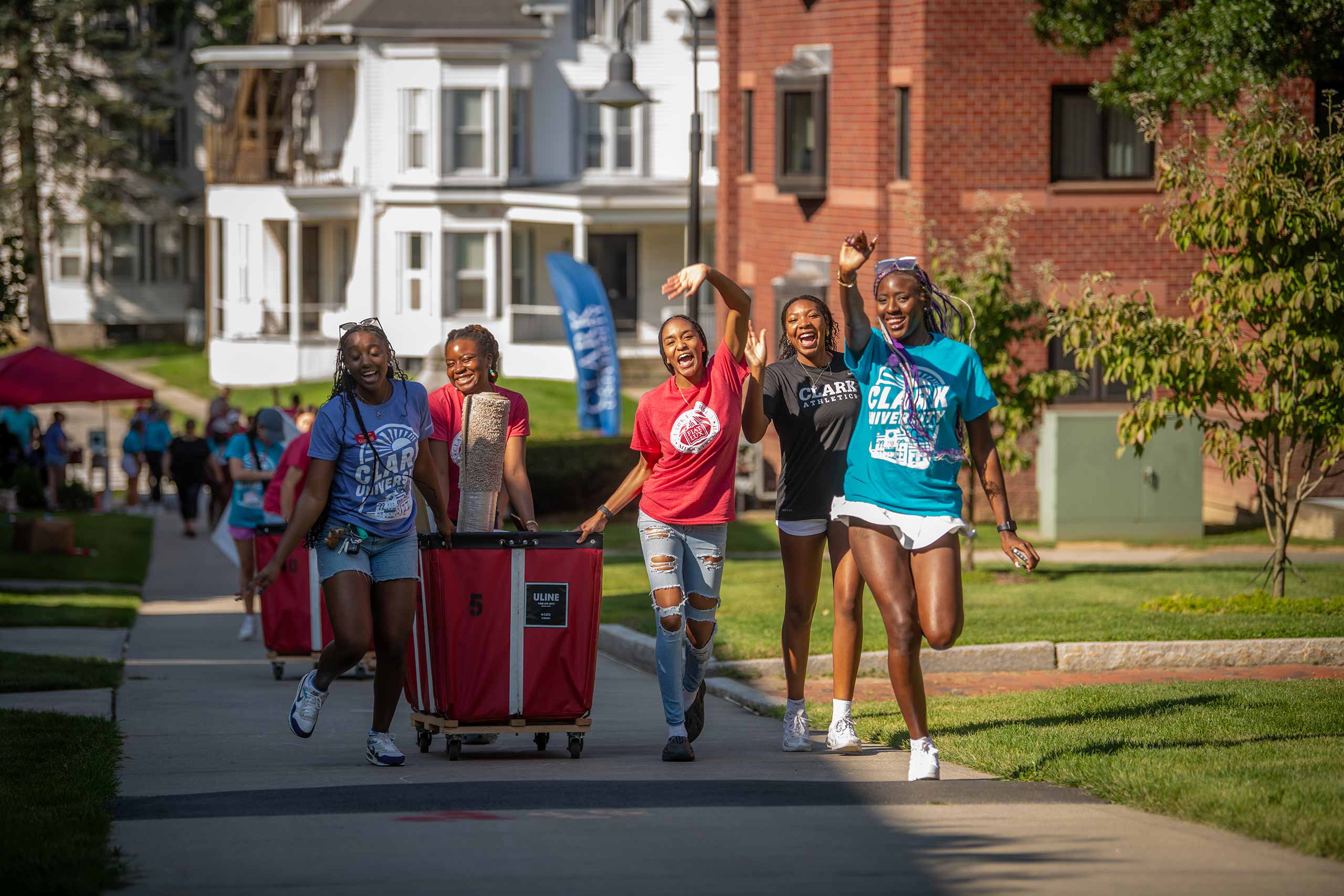 Peermentors rolling a cart to help students move in