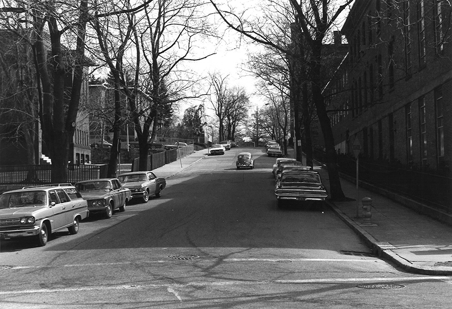 A VW Beetle travels up Woodland Street on the Clark University campus, 1964