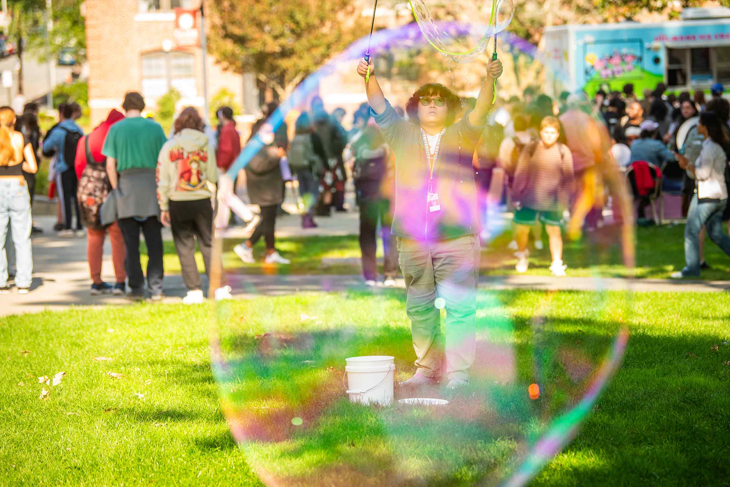 A person seen from the perspective of large soap bubbles during #FreshCheckDay, Clark University