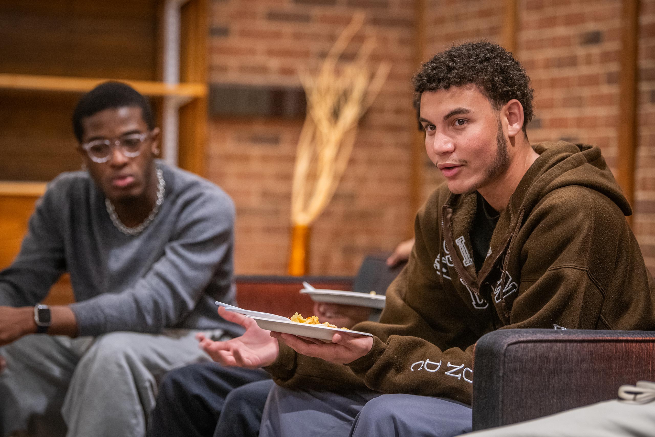 Students eat and converse at an event held by the Men of Color Alliance at Clark University
