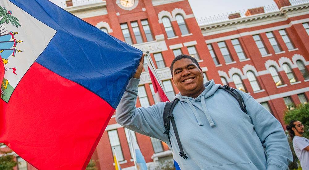 The homepage image from the Office of Identity, Student Engagement, and Access (ISEA) website showing William Stafford holding a Haitian flag