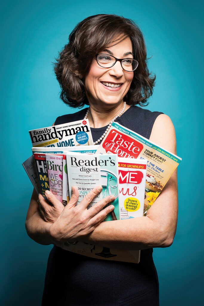 Bonnie Kintzer holding an assortment of Trusted Media Brands publications