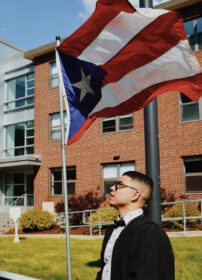 Student poses under Puerto Rico flag