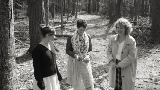 women standing in woods