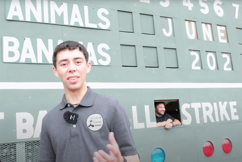 Noah Katz in front of the Fenway Park scoreboard