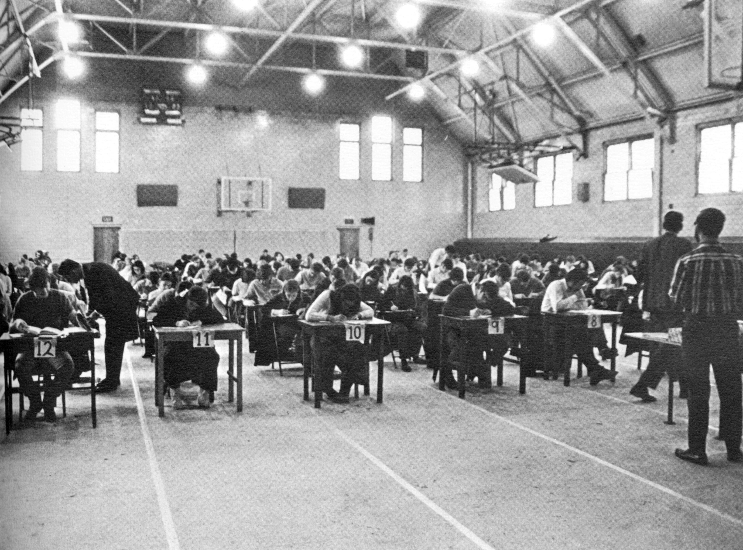 Students take exams in the gymnasium during the 1969–70 academic year.