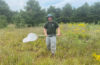 man in field with butterfly net