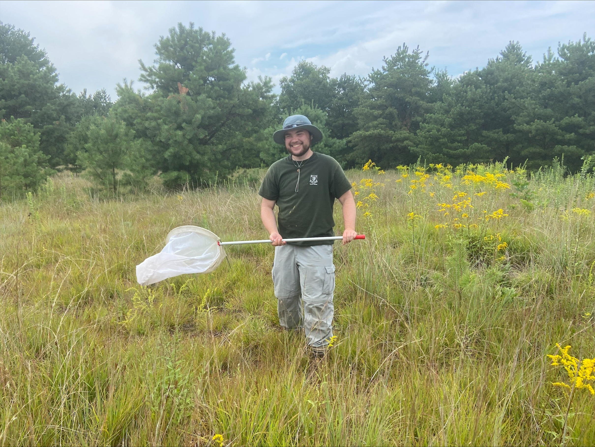 man in field with butterfly net