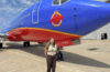 woman standing in front of blue airplane