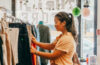 student looks through rack of pants